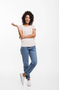 Kot pantolon ve t-shirt ayakta kolları olan giyen gülümseyen Amerikan kadın portresi tam uzunlukta katlanmış ve el el bir kenara beyaz arka plan üzerinde izole