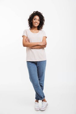 Kot pantolon ve t-shirt ayakta kolları olan giyen güzel Amerikalı kadın portresi tam uzunlukta katlanmış ve beyaz arka plan üzerinde izole gülümse