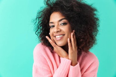 Güzel kadının 20'li yaşlarda mükemmel gülümsemeyle üzerinde mavi arka plan izole kamera seyir afro saç modeli ile çok renkli görüntü
