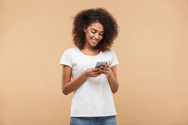 Portrait Smiling Young African Woman Using Mobile Phone Isolated Beige — Stock Photo, Image