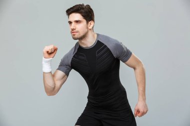 Konsantre genç sporcu izole gri arka plan üzerinde çalışmaya hazır portresi