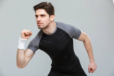 Odaklanmış bir genç sporcu izole gri arka plan üzerinde çalışmaya hazır portresi