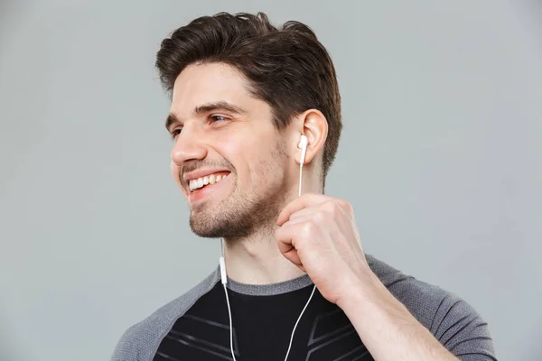 Close Portrait Smiling Young Sportsman Listening Music Earphones Isolated Gray — Stock Photo, Image