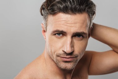 Fotoğraf gülümseyen olgun adam çıplak gri duvar arka plan üzerinde izole ayakta. Görünümlü kamera.