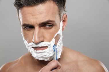 Görüntü üzerine gri duvar arka plan çıplak tıraş izole ayakta olgun adam.