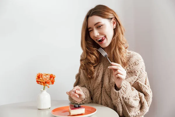 Imagen Mujer Caucásica Complacida Sentada Mesa Comiendo Pastel Usando Tenedor — Foto de Stock