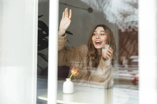 Sorrindo Jovem Mulher Suéter Segurando Xícara Café Enquanto Sentado Mesa — Fotografia de Stock