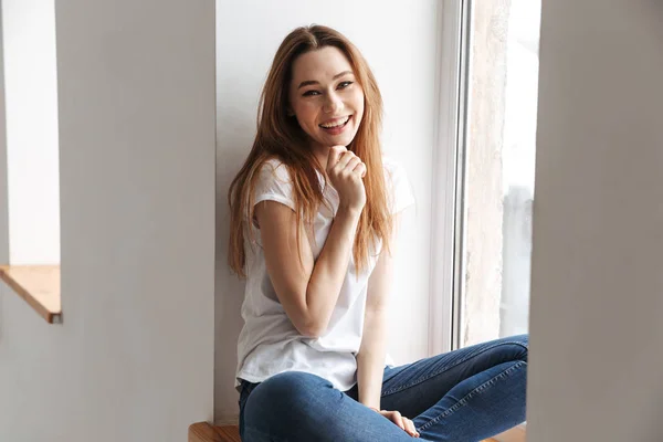 Lycklig Kvinna Shirt Som Sitter Fönsterkarm Medan Håller Hennes Haka — Stockfoto