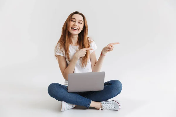 Mujer Feliz Camiseta Sentada Suelo Con Computadora Portátil Mientras Señala —  Fotos de Stock