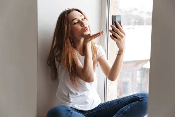 Όμορφη Γυναίκα Μπλουζάκι Που Κάθεται Στο Περβάζι Και Καθιστώντας Selfie — Φωτογραφία Αρχείου