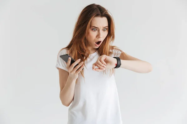 Σοκαρισμένος Γυναίκα Casual Ρούχα Κρατώντας Smartphone Ενώ Κοιτάζοντας Ρολόι Χεριού — Φωτογραφία Αρχείου