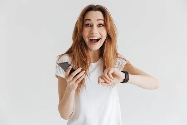 Έκπληκτος Ευτυχισμένη Γυναίκα Casual Ρούχα Ρολόι Χεριού Ενώ Κρατάτε Smartphone — Φωτογραφία Αρχείου