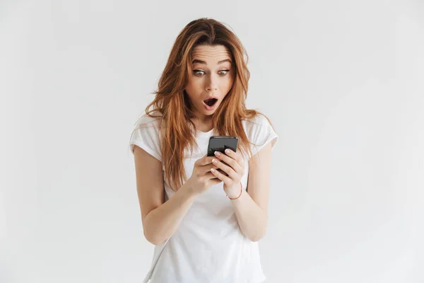 Retrato Una Joven Impactada Sosteniendo Teléfono Móvil Aislado Sobre Fondo — Foto de Stock