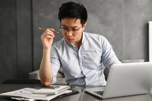 Portret Van Een Geconcentreerde Jonge Aziatische Man Met Laptopcomputer Zittend — Stockfoto