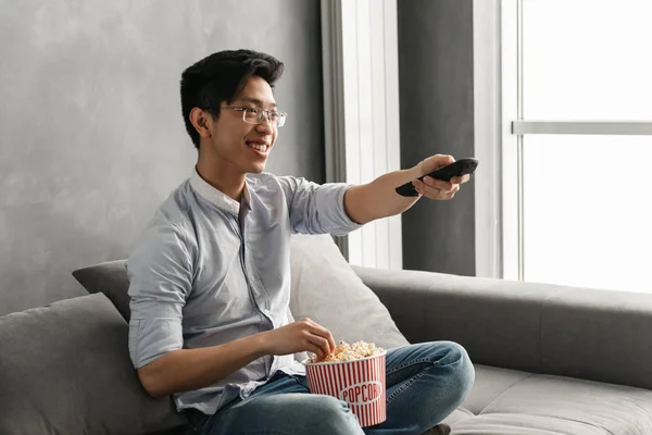 Portret Van Een Vrolijke Jonge Aziatische Man Met Popcorn Afstandsbediening — Stockfoto