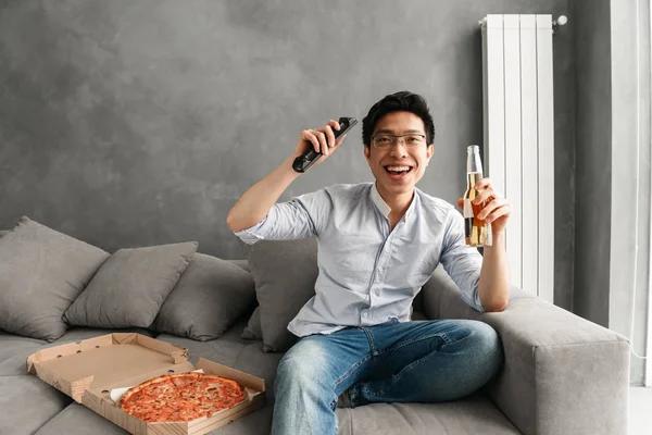 Portrait Excited Young Asian Man Holding Beer Bottle Remote Control — Stock Photo, Image