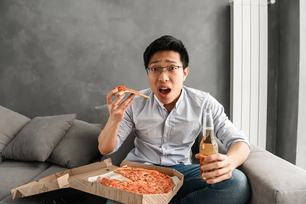 Portrait Confused Young Asian Man Eating Pizza Drinking Beer While — Stock Photo, Image