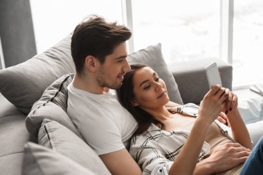 Muhteşem insanlar erkek ve evde koltukta yalan ve cep telefonuyla kadın portresi