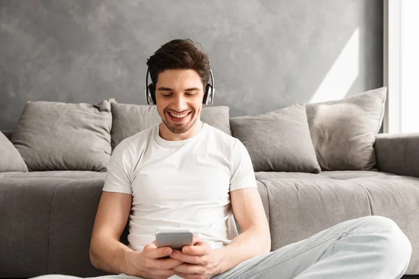 Vrolijke Man 30S Wit Shirt Vergadering Verdieping Binnen Luisteren Naar — Stockfoto