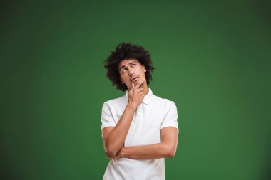 Fotoğraf genç Afrika kıvırcık adam yeşil duvar arka plan üzerinde izole ayakta düşünüyorum konsantre.