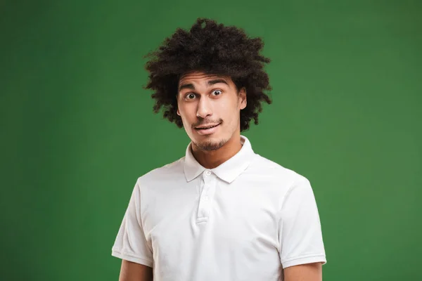 Foto Chocado Jovem Afro Encaracolado Homem Isolado Sobre Parede Verde — Fotografia de Stock