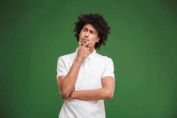 Photo Concentrated Thinking Young African Curly Man Standing Isolated Green — Stock Photo, Image