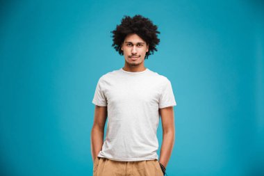 Görüntü izole kamera arıyorum mavi arka plan üzerinde duran Afrika yakışıklı genç.