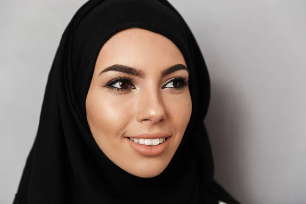 肖像特写穆斯林祈祷妇女20S 在宗教头巾与东方化妆微笑着 看着一旁孤立的灰色背景 — 图库照片