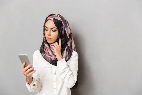 Portrait Upset Young Arabian Woman Looking Mobile Phone Isolated Gray — Stok Foto
