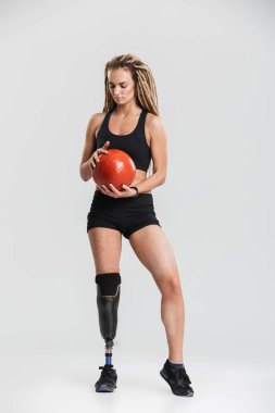 Topu ile egzersizleri yapmak imge-in sağlıklı bir genç Engelli sporcumuz gri arka plan üzerinde izole.