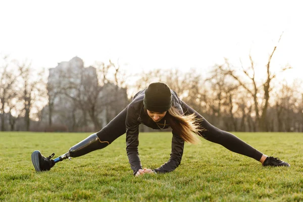 Foto Voor Gehandicapte Sportvrouw Zwart Trainingspak Rekken Prothese Been Zittend — Stockfoto