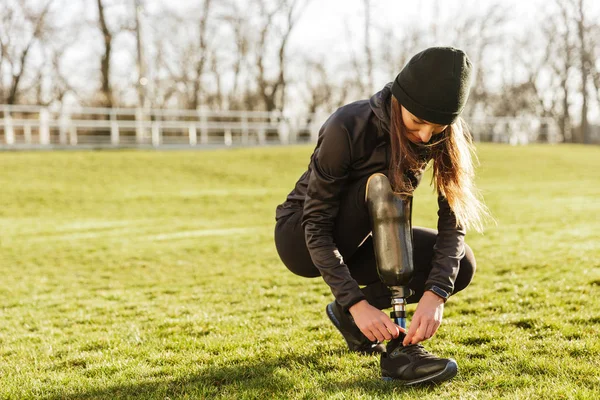 Imagen Una Joven Deportista Discapacitada Chándal Cuclillas Atando Cordones Zapatos — Foto de Stock