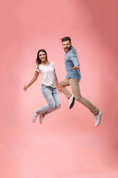 Full Length Portrait Cheerful Young Couple Holding Hands While Jumping — Stock Photo, Image