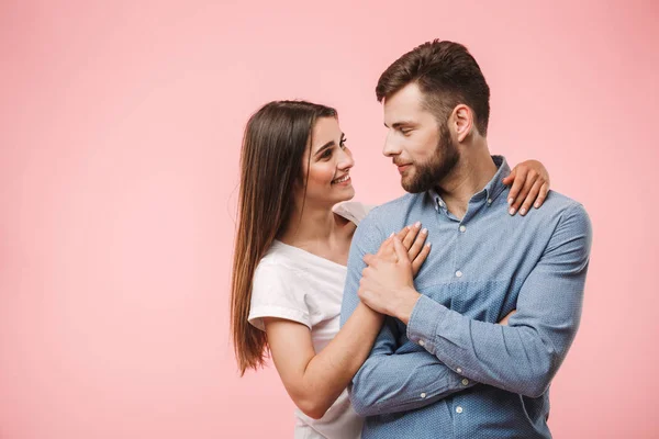 一对爱的年轻夫妇拥抱 而站在粉红色背景孤立的肖像 — 图库照片