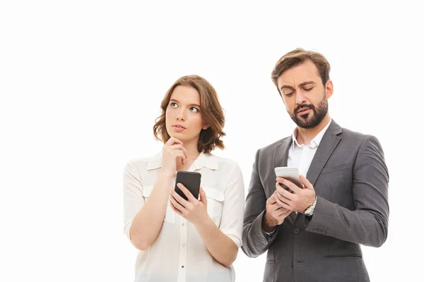 Retrato Una Pareja Negocios Pensativa Sosteniendo Teléfonos Móviles Pensando Aislado — Foto de Stock