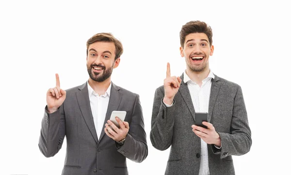 Retrato Dois Homens Negócios Satisfeitos Segurando Telefones Celulares Apontando Para — Fotografia de Stock