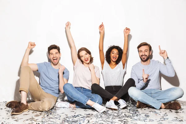 Group Happy Multiracial People Sitting Floor Confetti Celebrating Isolated White — Stock Photo, Image