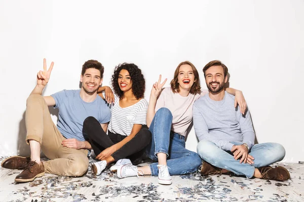 Group Happy Multiracial People Sitting Floor Confetti Isolated White Background — Stock Photo, Image