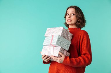 Yorgun bir genç kadının portresi büyük mevcut kutuları üzerinde mavi arka plan izole yığını tutan kazak giymiş