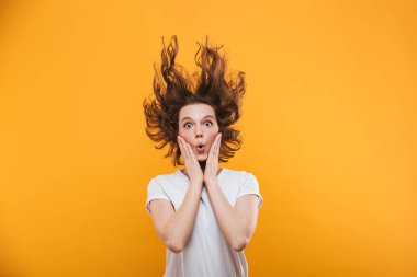 Görüntü izole kamera seyir sarı arka plan üzerinde duran şok genç kadın.