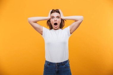 Görüntü izole kamera seyir sarı arka plan üzerinde duran şok genç kadın.