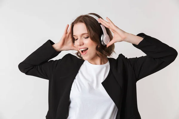 ヘッドフォンで音楽を聴く分離を立っている感情的な若い女性の画像 — ストック写真