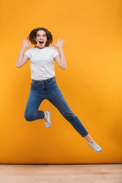 Photo Emotional Young Woman Jumping Isolated Yellow Background Looking Camera — Stock Photo, Image