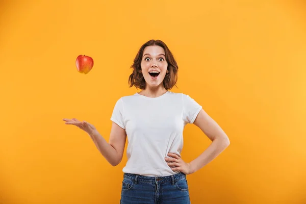 Image Happy Shocked Young Woman Standing Isolated Yellow Background Apple — Stock Photo, Image