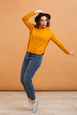 Görüntü izole giyen şapka dans duygusal güzel genç kadın.