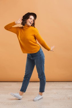 Görüntü izole giyen şapka dans duygusal güzel genç kadın.