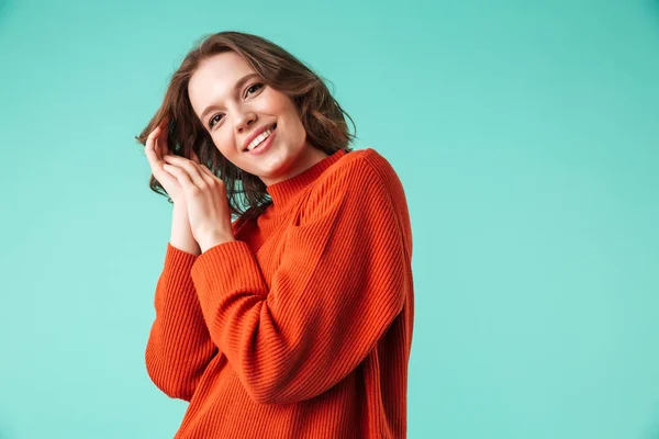青い背景に分離カメラ目線のセーターを着て陽気な若い女性の肖像画 — ストック写真
