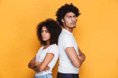 Kızgın bir afro Amerikan çift portre sarı arka plan üzerinde tartışıyor ve sırt sırta duran izole