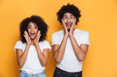 Azarlama bir neşeli genç afro Amerikan Çift sarı arka plan üzerinde izole portre