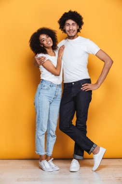 Sarı arka plan üzerinde izole mutlu afro Amerikan çifte sarılma tam uzunlukta portresi
